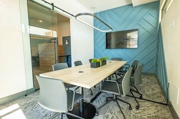 A conference room with a long table and chairs.